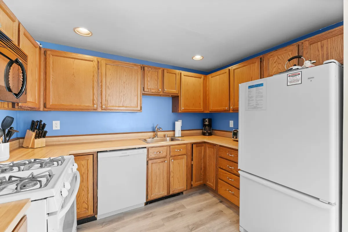 A warm, inviting kitchen with wooden cabinets, ample countertop space, and modern appliances ready for cooking. The kitchen layout is open and functional, suggesting plenty of space for preparing family meals and gathering together.
